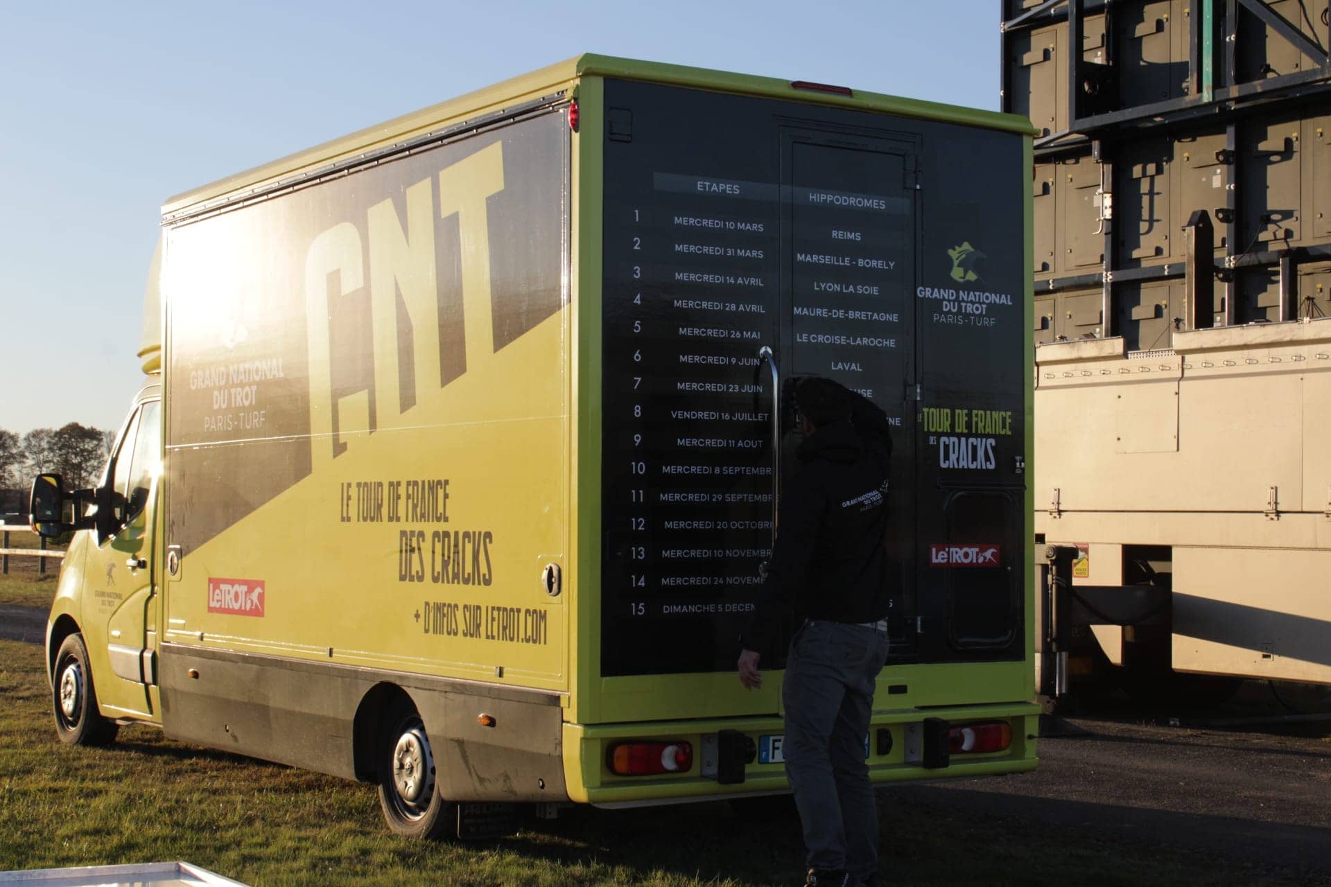 Camion podium Grand National du Trot - covering intégral jaune et vert avec calendrier des étapes sur le flanc