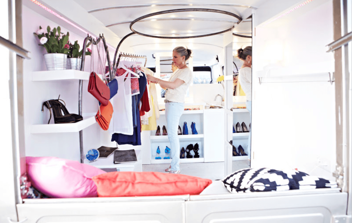 Cliente dans le fashion truck - intérieur avec étagères et penderies