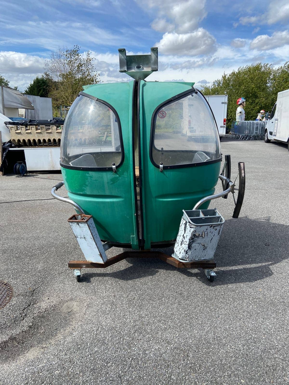 Télécabine Megg verte sur ses pieds à roulettes, photographiée en extérieur