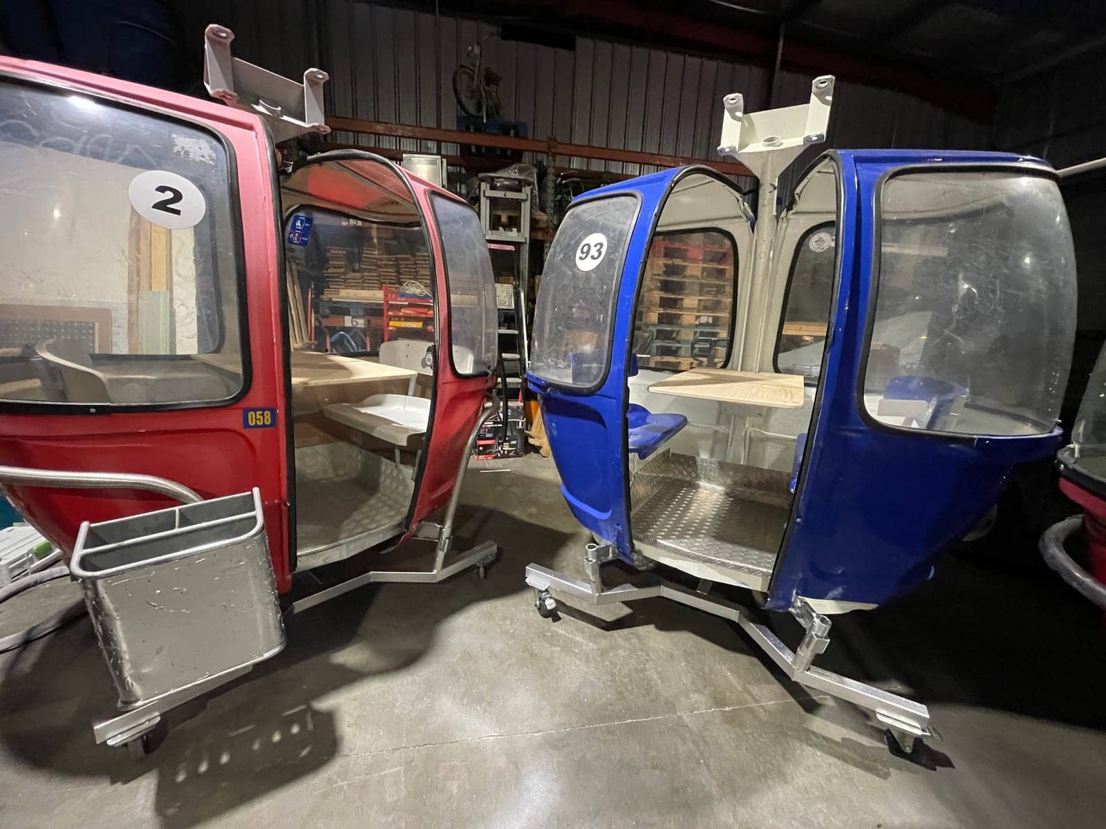 Télécabine Megg rouge et télécabine bleue numéro 93, portes ouvertes et tablettes installées, prêtes pour un événement