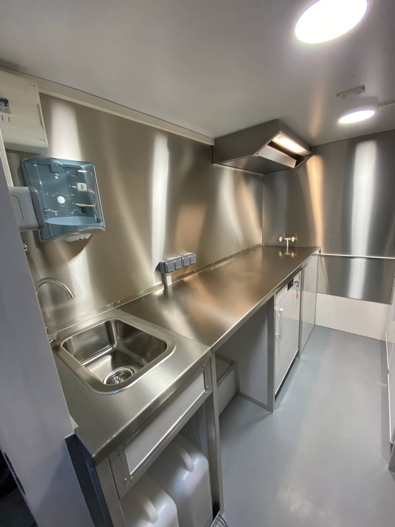 Vue comptoir camion crêpes avec vitrine réfrigérée, plan de travail inox, hotte et réfrigérateurs sous comptoir