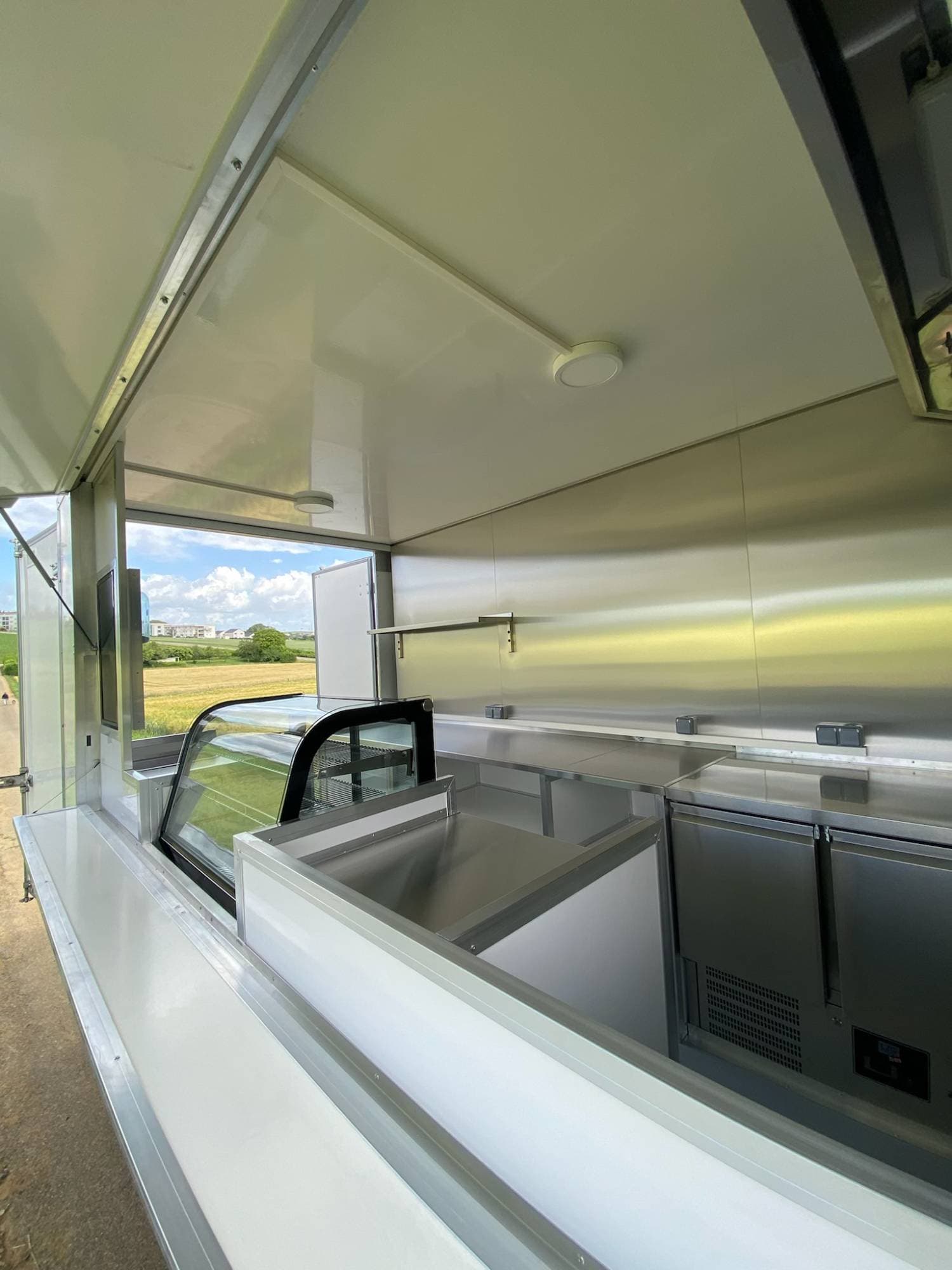 Vue comptoir camion traiteur avec vitrine réfrigérée courbe, comptoirs réfrigérés inox et ouverture de service