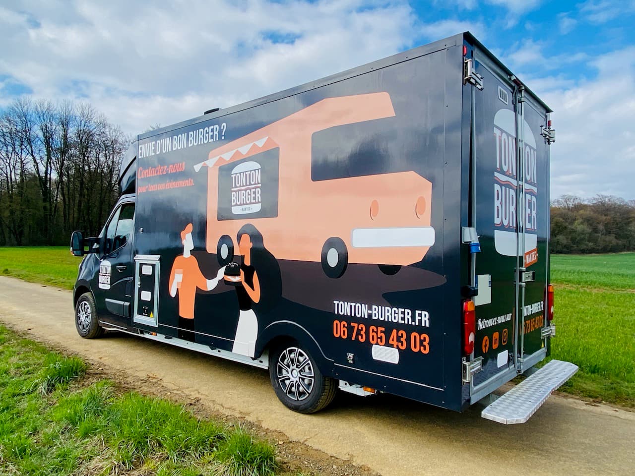 Food truck Tonton Burger vue arrière avec covering illustré et coordonnées tonton-burger.fr en campagne