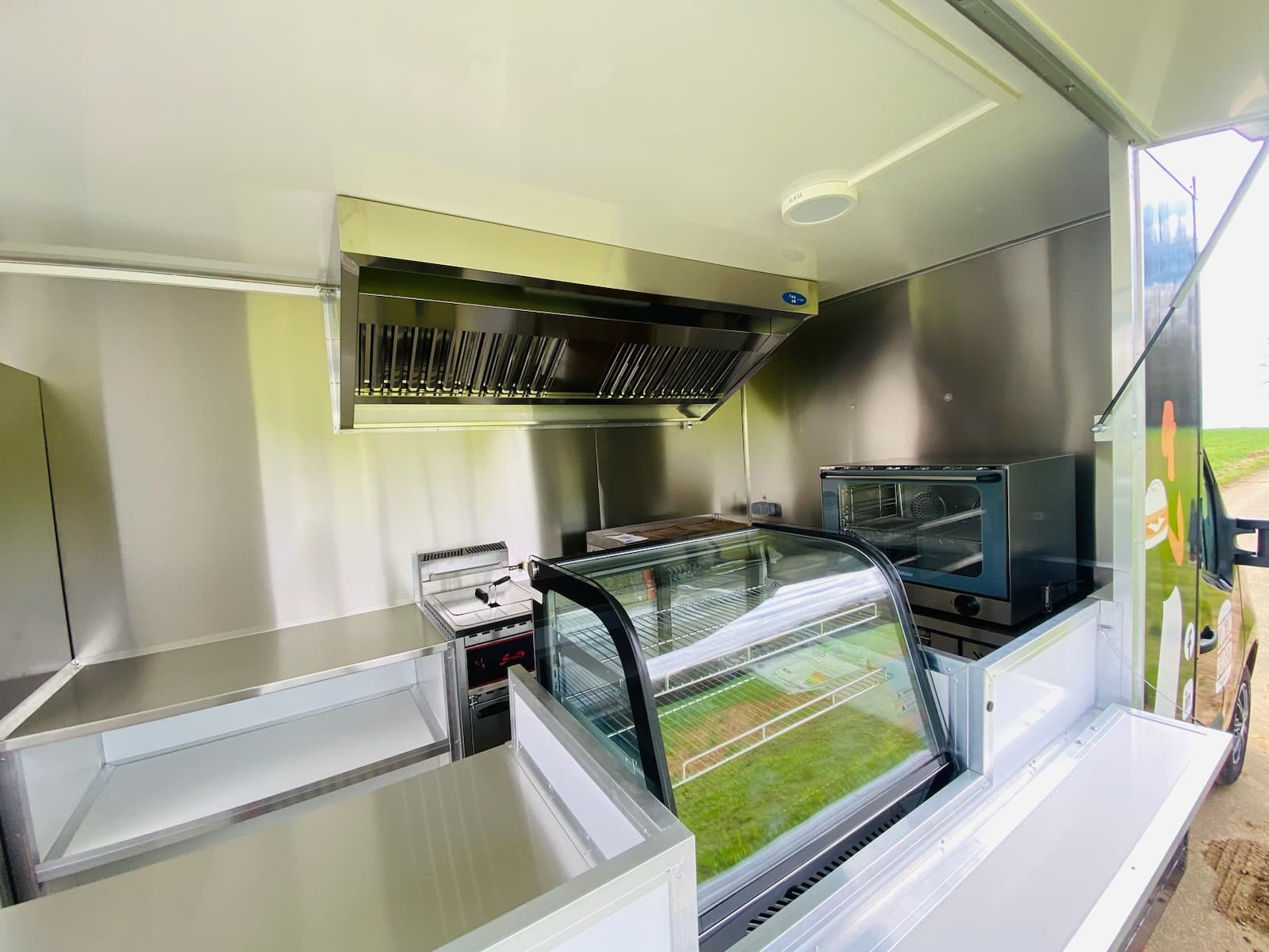 Intérieur cuisine du food truck Tonton Burger avec vitrine réfrigérée four et hotte en inox