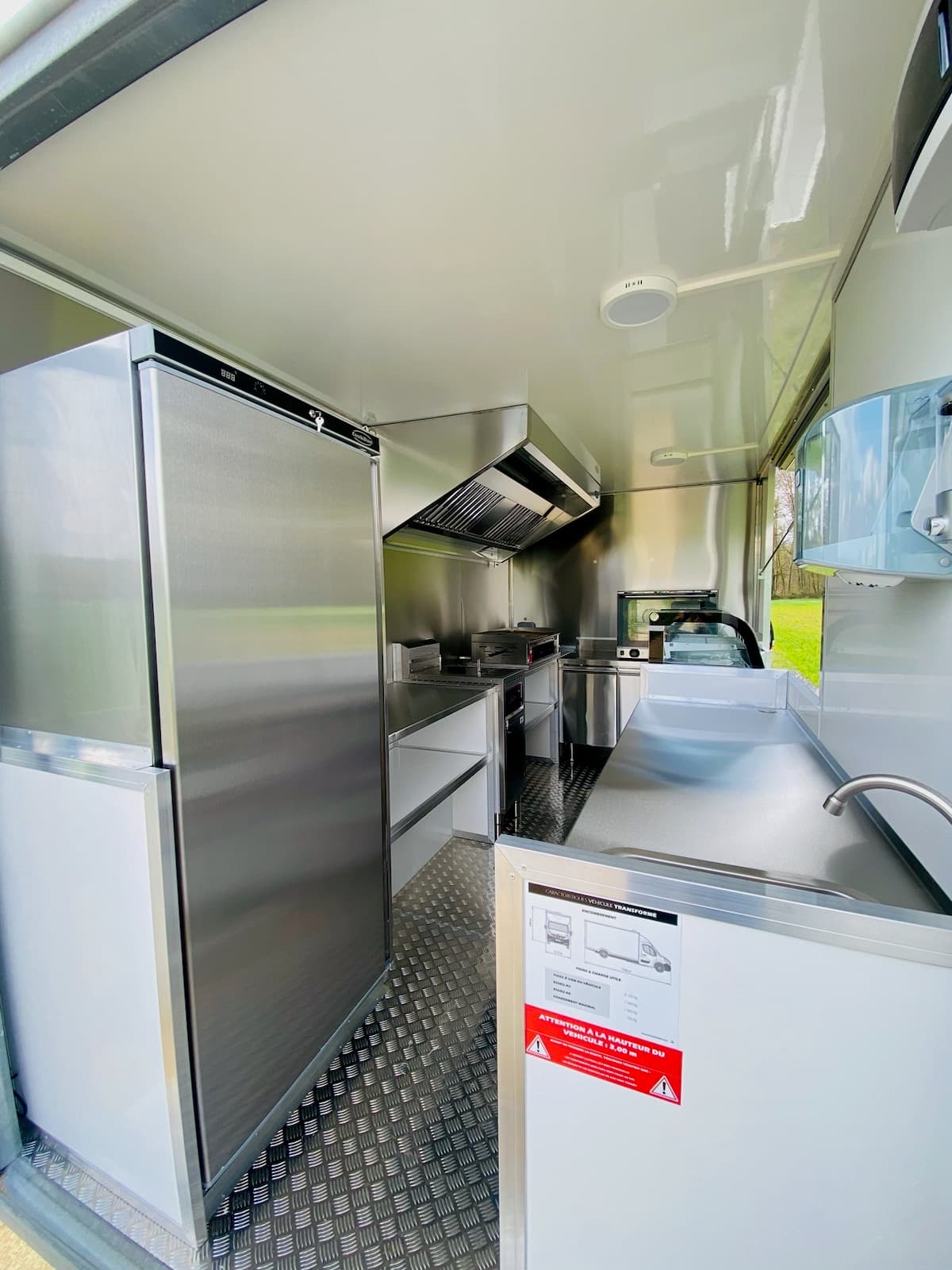Intérieur professionnel du food truck Tonton Burger avec réfrigérateur inox plancha et évier