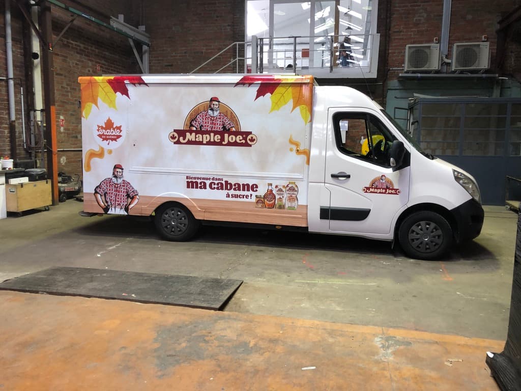 Food truck Maple Joe vue latérale avec covering cabane à sucre et feuilles d'érable dans un entrepôt