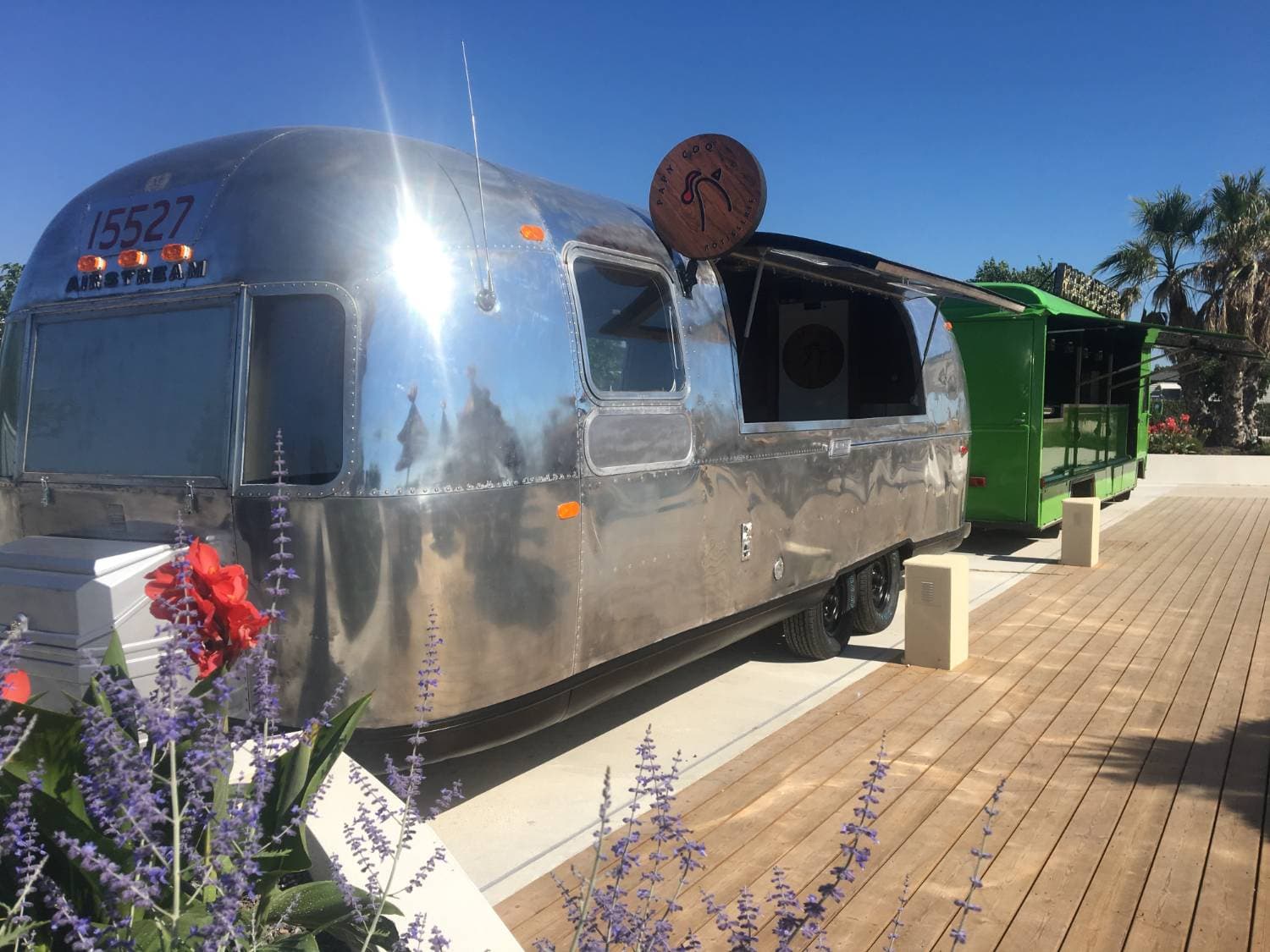 Airstream Papy Coq - vue latérale avec coque aluminium et enseigne ronde en bois