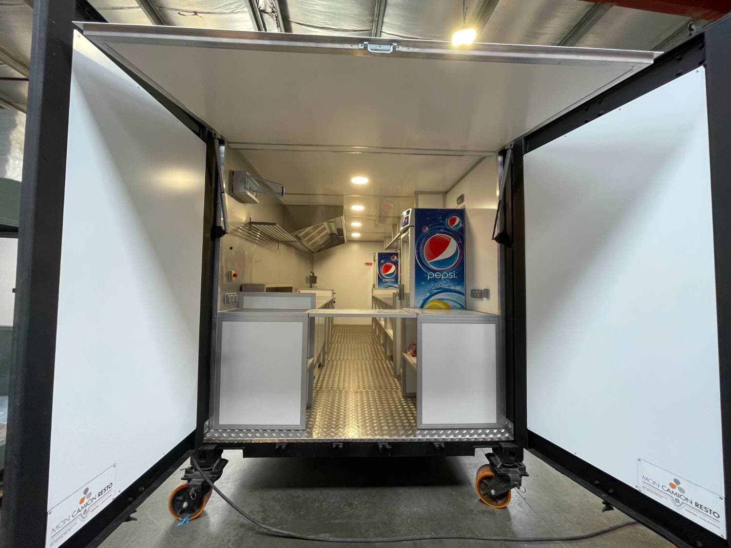 Vue arrière portes ouvertes - cuisine complète visible, logo Mon Camion Resto