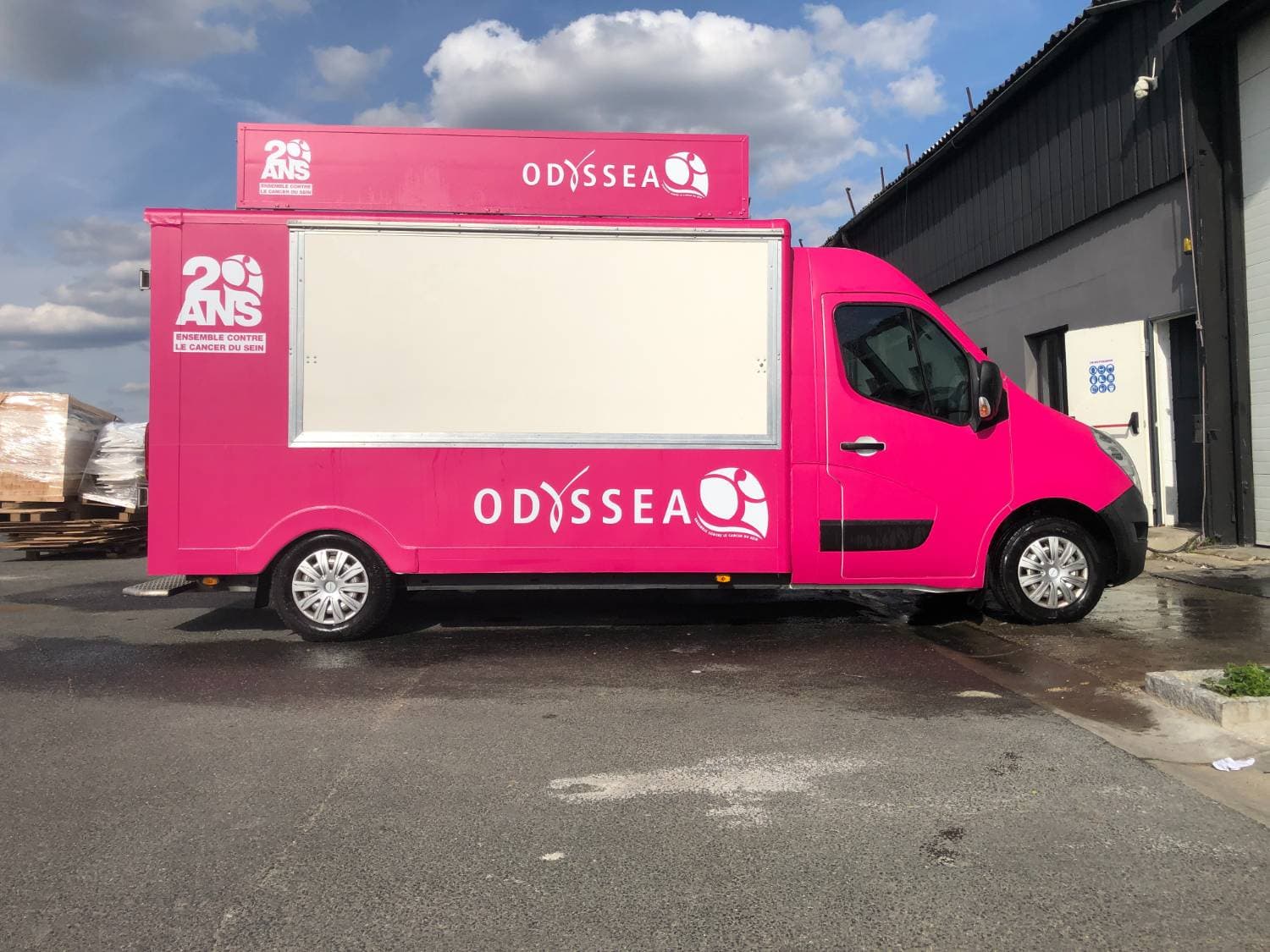 Vue latérale du food truck Odyssea rose avec impression grand format et volet de service