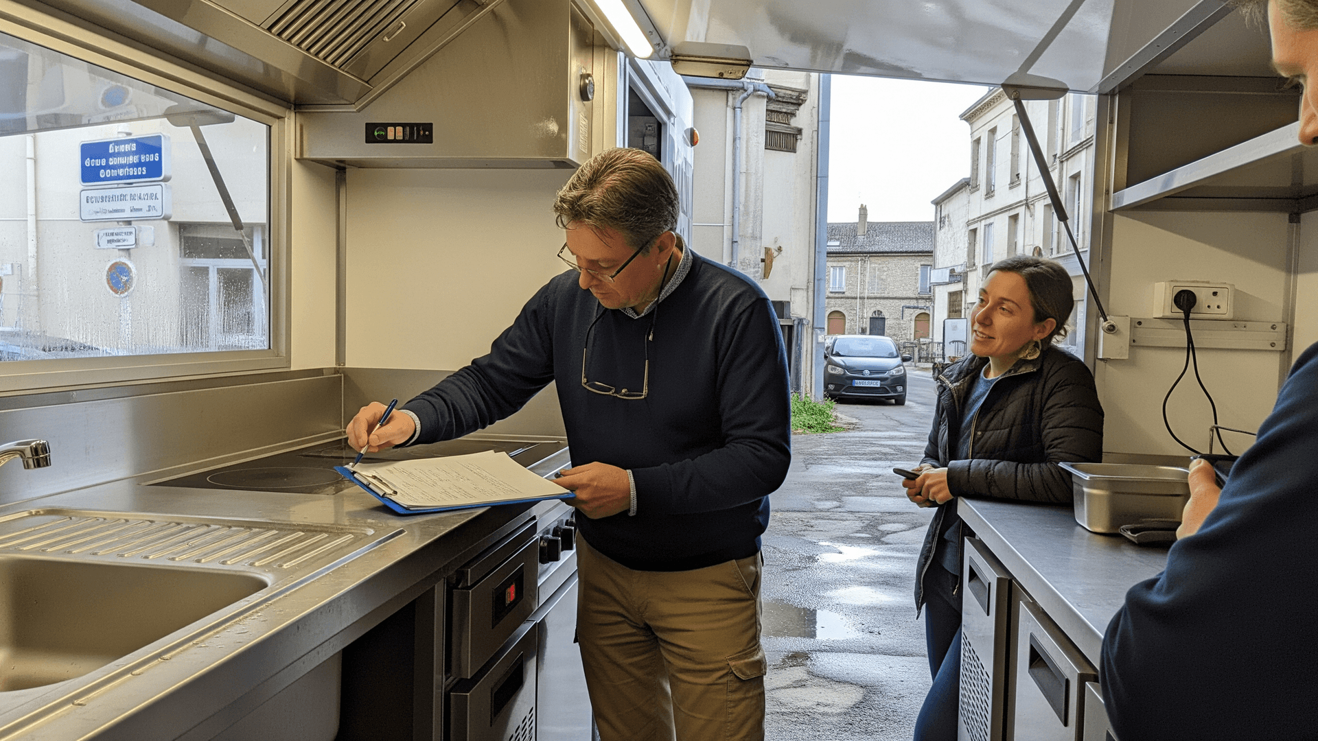 Contrôle détaillé de la cuisine professionnelle en inox d'un food truck : évier, plaques de cuisson, hotte. Essentiel pour l'homologation VASP.
