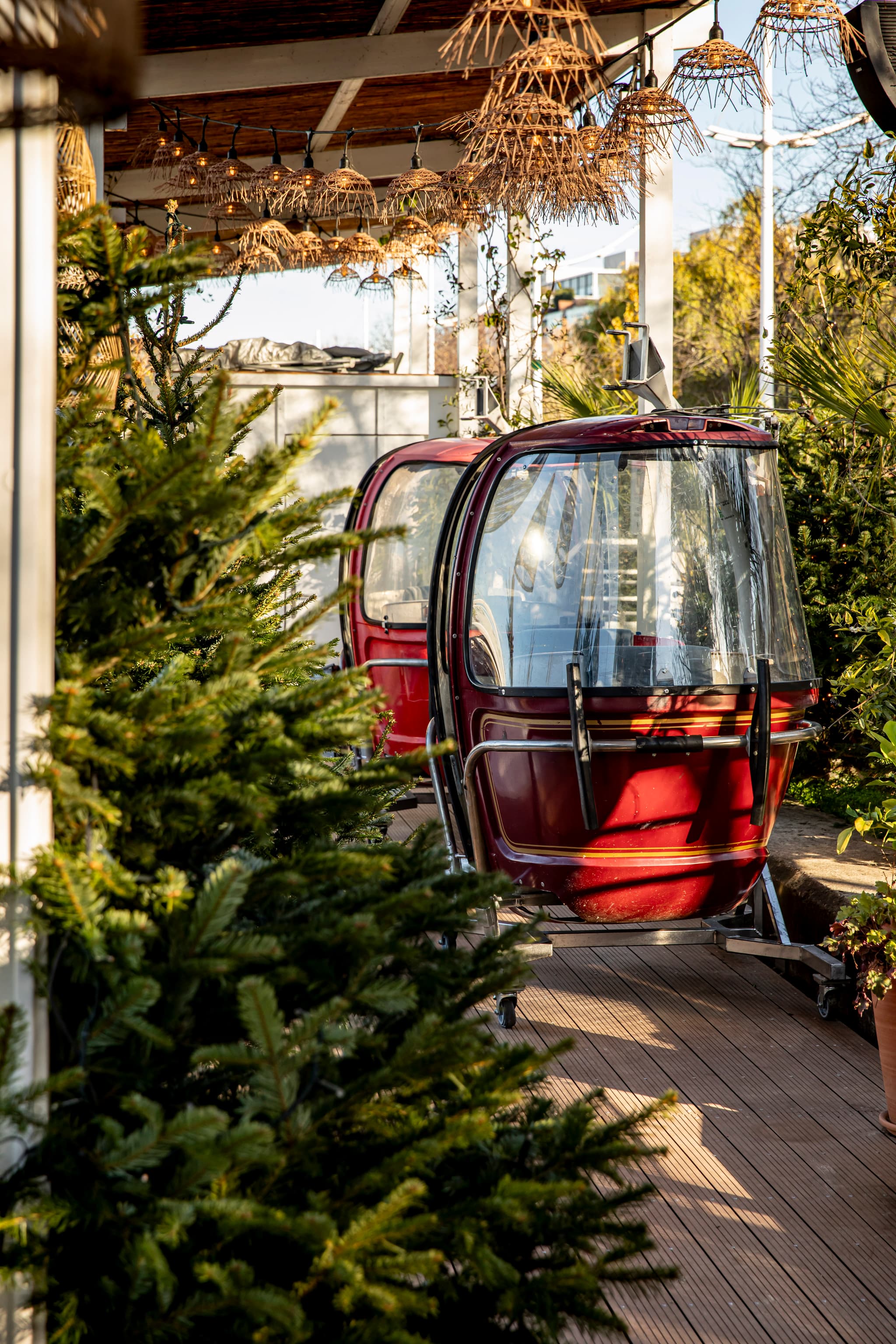 Télécabines MEGG rouges installées au restaurant Polpo - ambiance hivernale avec sapins